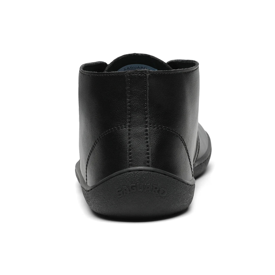 Vista posterior del zapato formal negro mostrando la suela plana sin elevación de talón.