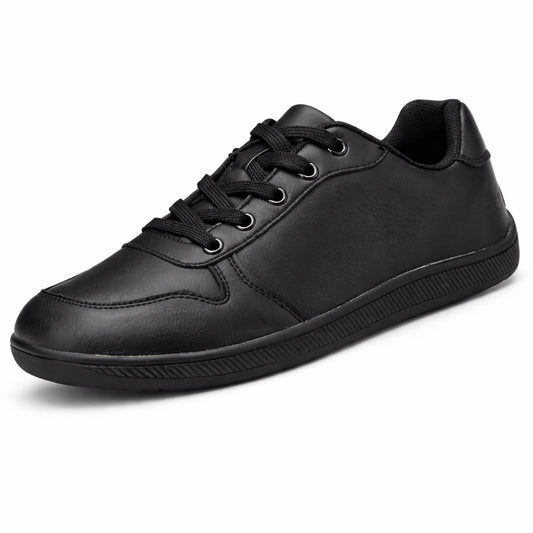Zapatilla minimalista negra de piel sintética, estilo urbano y oficina.