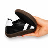 Zapatillas minimalistas negras ZZFABER Niza 2.0 dobladas al máximo, demostrando la alta flexibilidad de su suela de caucho drop cero en Chile.